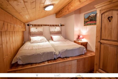 a bedroom with a bed in a wooden room at Chez Mamie Anna (B&B et Chalet) in Bessans