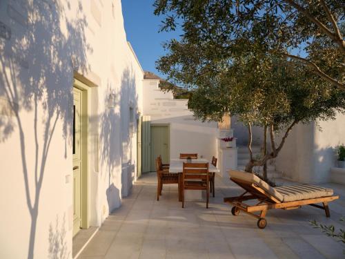 a patio with a table and chairs and a tree at Marble Villas in Ekatondapilianí