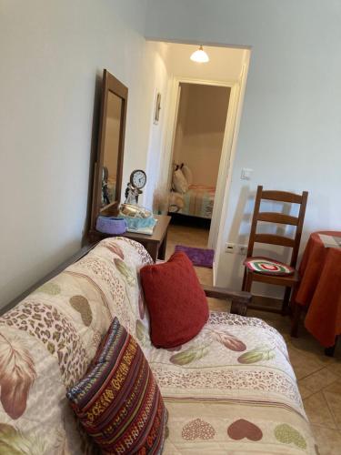 a living room with a couch and a mirror at AGKYRA Rooms (Faith) in Andros
