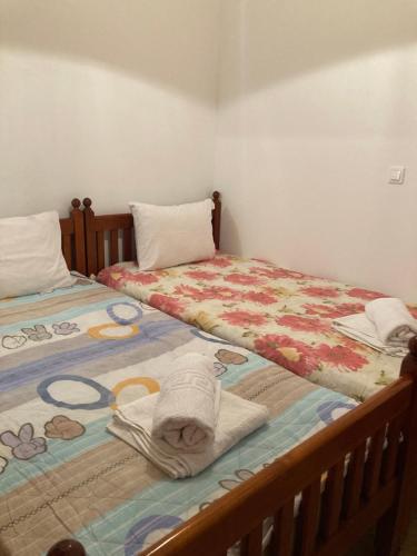 two beds sitting next to each other with towels on them at AGKYRA Rooms (Faith) in Andros
