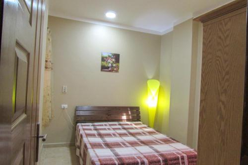 ein kleines Schlafzimmer mit einem Bett mit einer karierten Decke in der Unterkunft Apartments Desert rose near the sea RedSeaLine in Hurghada