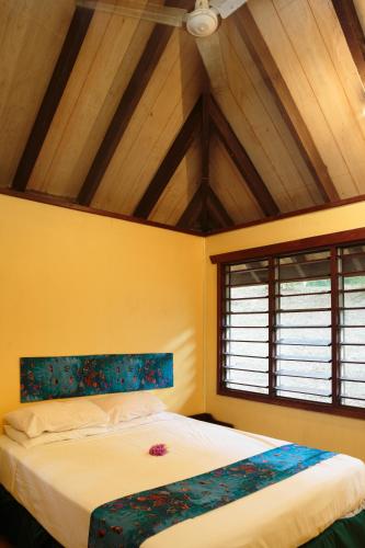 a bedroom with a large bed with a wooden ceiling at Funky Fish Beach & Surf Resort in Malolo