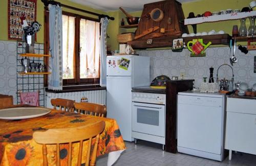 kuchnia ze stołem i białą lodówką w obiekcie Chalet Gineprino w mieście Vallombrosa
