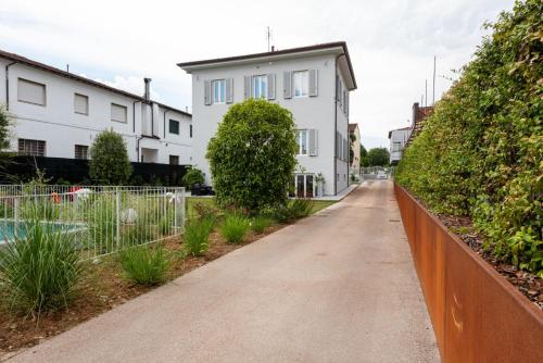 an empty street with white houses and a fence at Villa Fedora Luxury Suites in Lucca
