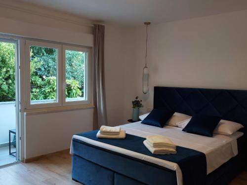 sypialnia z niebieskim łóżkiem i 2 ręcznikami w obiekcie Meden Apartment w Poreču