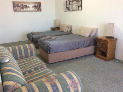 a living room with a bed and a couch at New Whyalla Hotel in Whyalla