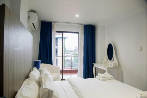 two beds in a room with a window at WDC APARTHOTEL - BUEA in Buea