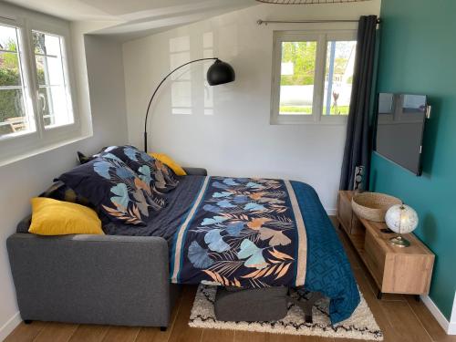 una camera da letto con un letto coperto di *** Domaine des Noyers - Proche centre Ville a Châteauneuf-sur-Loire