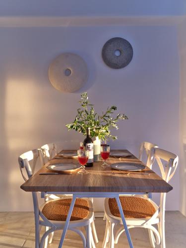 a wooden table with chairs and wine glasses at Marble Villas in Ekatondapilianí