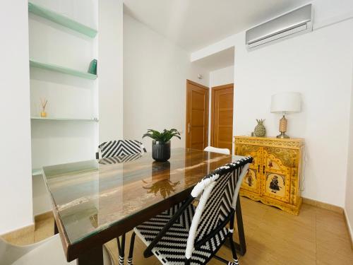 a dining room with a glass table and two chairs at Apartamento Ría Punta Umbría in Punta Umbría