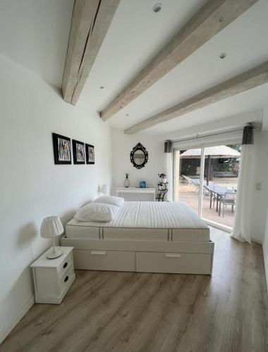 une chambre blanche avec un lit et une fenêtre dans l'établissement Gîte Vue Mer, à La Cadière-dʼAzur