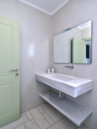 a bathroom with a sink and a mirror at Marble Villas in Ekatondapilianí