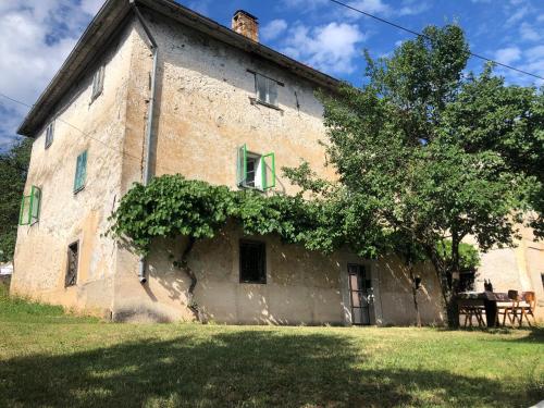 an old stone building with a tree in front of it at Cultural monument House Vecchia in Otočac