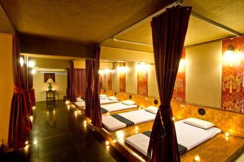 eine Reihe Betten in einem Zimmer mit Spiegeln in der Unterkunft Fortuna Hotel in Bangkok