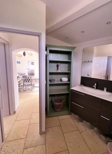 La salle de bains est pourvue d'un lavabo, d'un miroir et d'une table. dans l'établissement Gîte Vue Mer, à La Cadière-dʼAzur