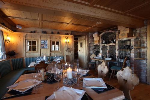 a dining room with a table with glasses and candles at Hôtel 3 étoiles -Restaurant Le Pilatus Courchevel in Courchevel