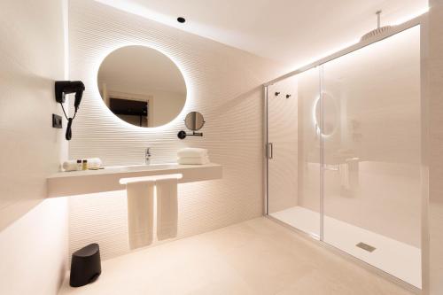 a bathroom with a shower and a sink and a mirror at Hotel Primavera Park in Benidorm