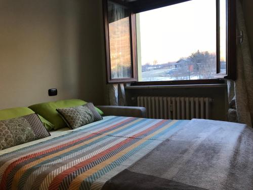 Un dormitorio con una cama con una manta de colores. en Fiordaliso, en Aosta