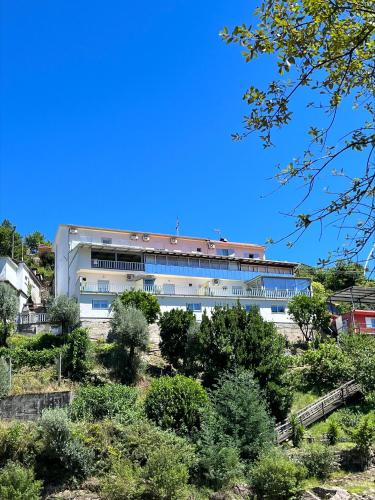 a large white building with a red roof at Alojamento Por do Sol in Geres