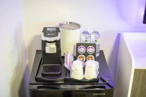 a coffee maker with bottles of water on a table at WAFER 450 Hotel in Santa Clara