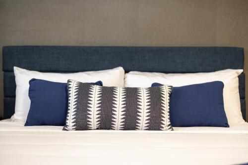 a bed with blue and white pillows on it at WAFER 450 Hotel in Santa Clara