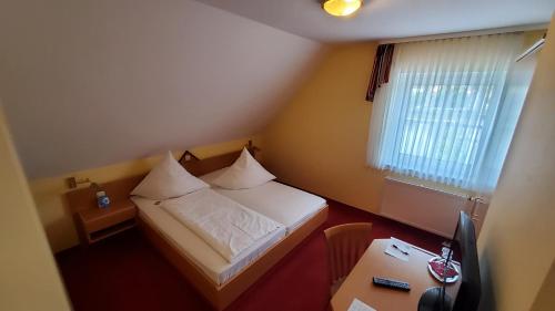 a small room with a bed and a desk at Hotel-Café 3 Kronen in Burglengenfeld