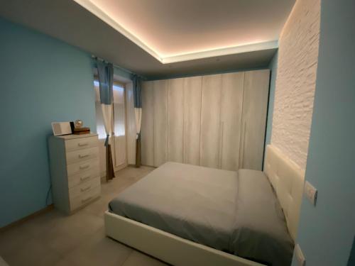 - une petite chambre avec un lit et une commode dans l'établissement Casa Martina, à Coni