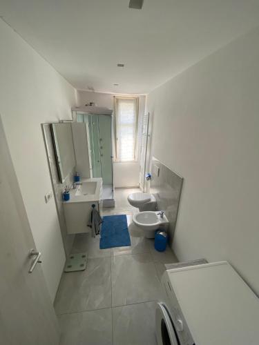 a bathroom with two sinks and a toilet and a mirror at Casa Martina in Cuneo
