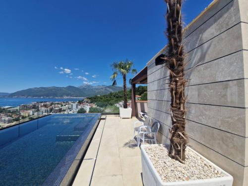 una casa con piscina y una palmera en Eden apartments, en Tivat