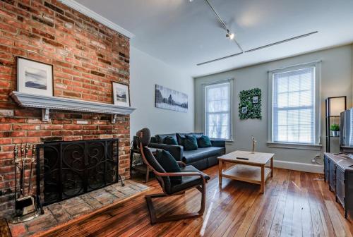 a living room with a brick wall and a fireplace at 3BR Colonial House with Parking by CozySuites in Alexandria