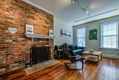 a living room with a brick wall and a fireplace at 3BR Colonial House with Parking by CozySuites in Alexandria