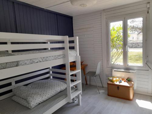 a bedroom with two bunk beds and a desk at Maison les pieds dans la mer in Quinéville