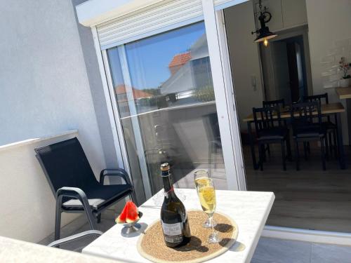 a bottle of champagne and two glasses on a table at Apartman Ivana in Split