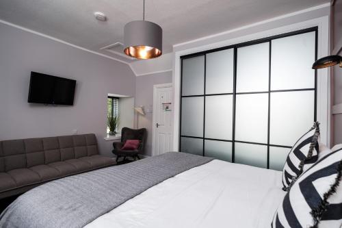 a bedroom with a large bed and a couch at The Cock and Bull in Balmedie
