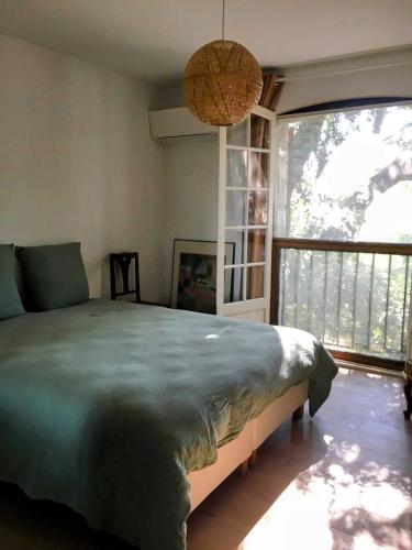 穆昂萨尔图Villa familiale avec piscine à Mouans-Sartoux的一间卧室，配有一张大床和一扇大窗户。