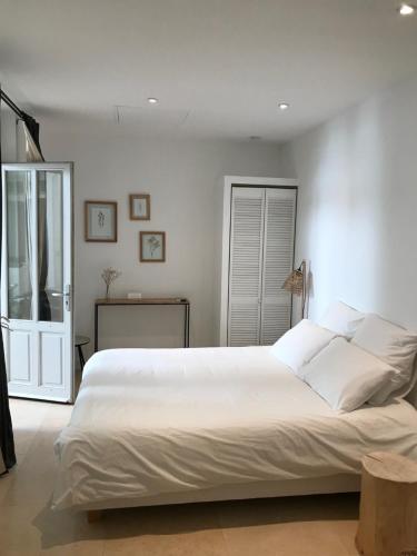 a bedroom with a large white bed and a window at Maison Boussingault in Avignon