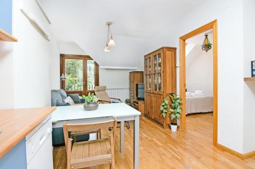 uma cozinha e sala de estar com uma mesa e um sofá em CASA BEGOÑA - Wifi, sencillo y acogedor em Sallent de Gállego