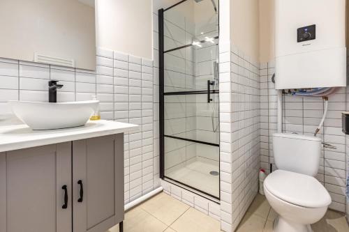 Un baño con inodoro y ducha de cristal. en Charmant Appartement en Hypercentre, en Toulouse