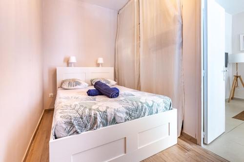 Un dormitorio con una cama blanca con almohadas azules. en Charmant Appartement en Hypercentre, en Toulouse