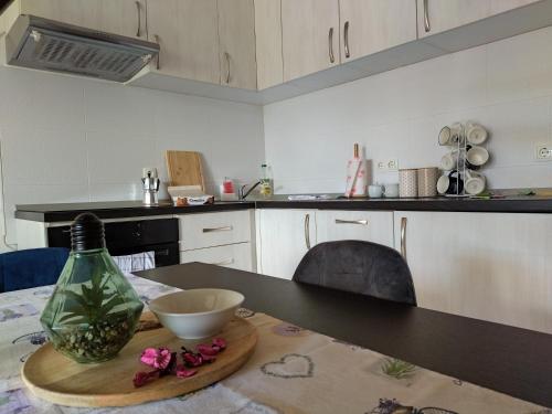 una cocina con una mesa con un bol y una botella en Apartman Ana en Mrkopalj