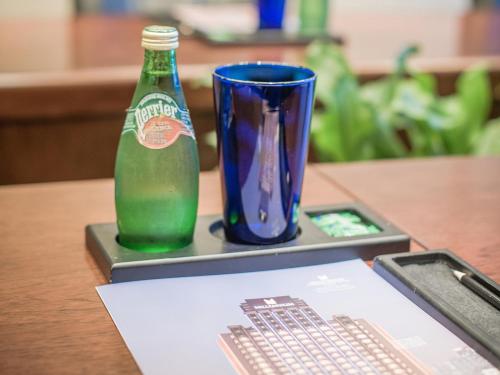 a bottle of soda and a cup on a table at Millennium Harbourview Hotel Xiamen-Near Metro Station & Zhongshan Road in Xiamen