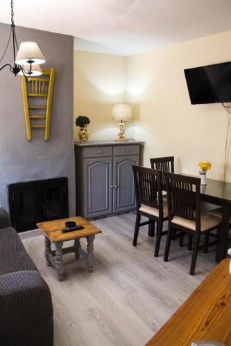 a living room with a fireplace and a table and chairs at Apartamentos Vista Veleta in Capileira