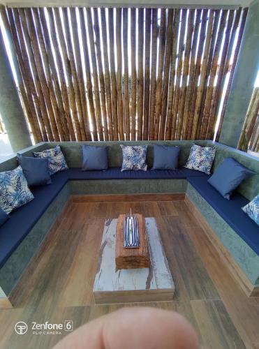 a living room with a blue couch with a table at Tronco do Ipê Hospedagem in Alto Paraíso de Goiás