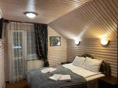 um quarto com uma cama com duas toalhas em Котедж em Vorokhta