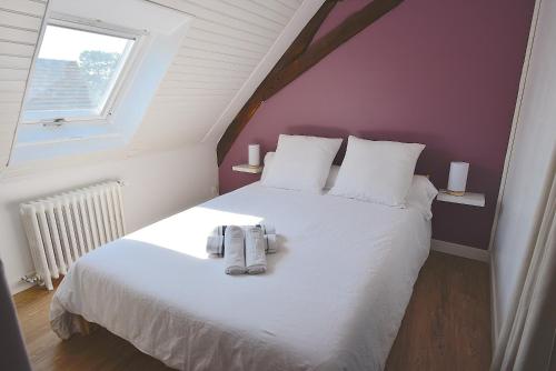 een slaapkamer met een wit bed met twee schoenen erop bij Welcome Home in Linas