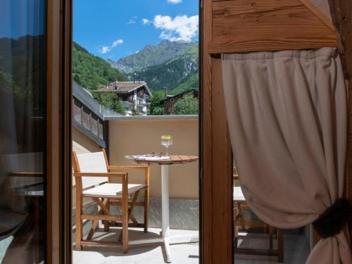 a balcony with a table and a view of a mountain at Gran Baita Hotel & Wellness in Courmayeur