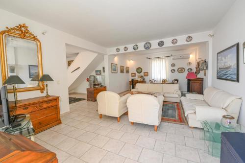 a living room with white furniture and a mirror at Alento Apartments in Tinos Town