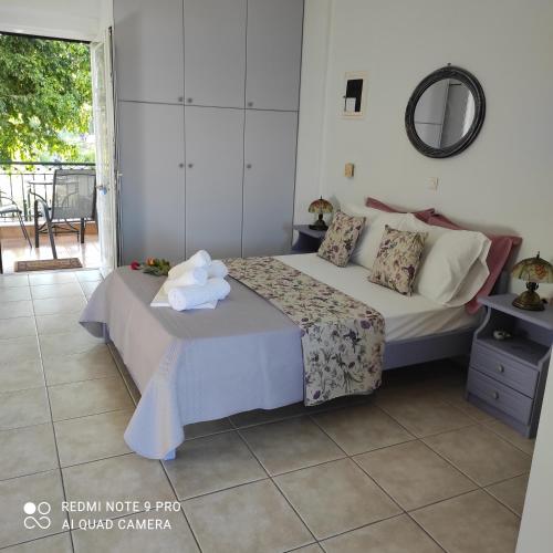 a bedroom with a bed and a table with a mirror at ARETI APARTMENTS in Petalidi