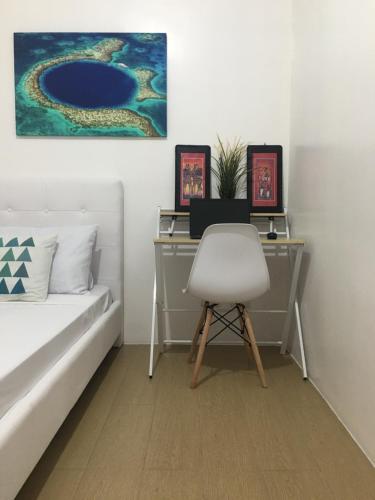 a bedroom with a desk and a chair next to a bed at Budget Friendly-Spacious One Bedroom Suite Opposite to Naia 3 in Manila