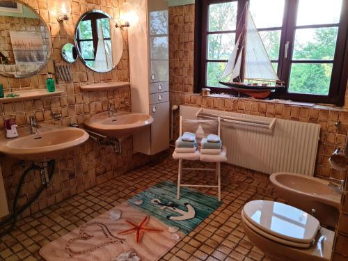 un baño con dos lavabos y un barco pirata en el suelo en Ferienwohnung op de Warft, en Neukirchen